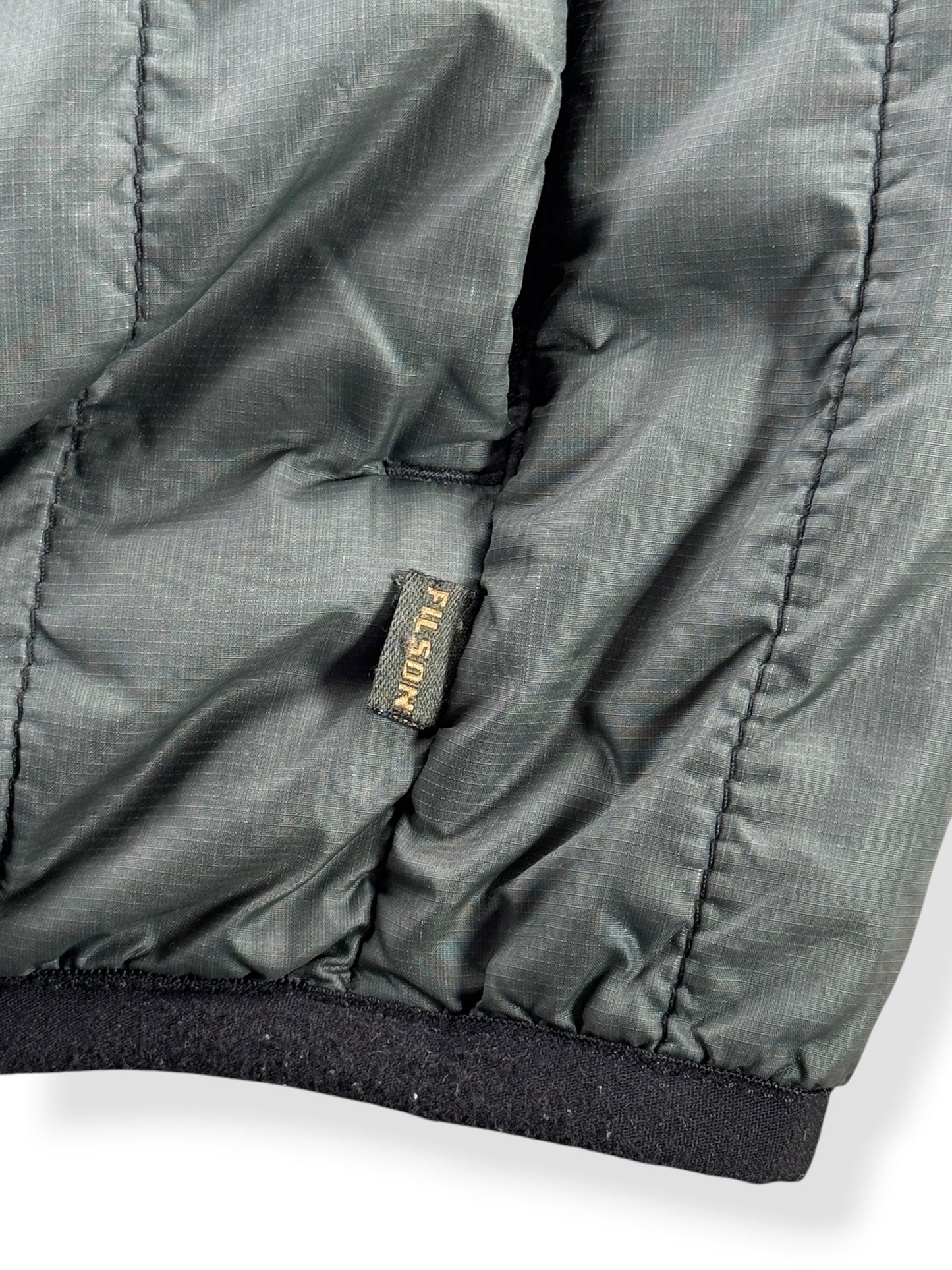 Filson tag on side of Filson Quilted Vest SZ M