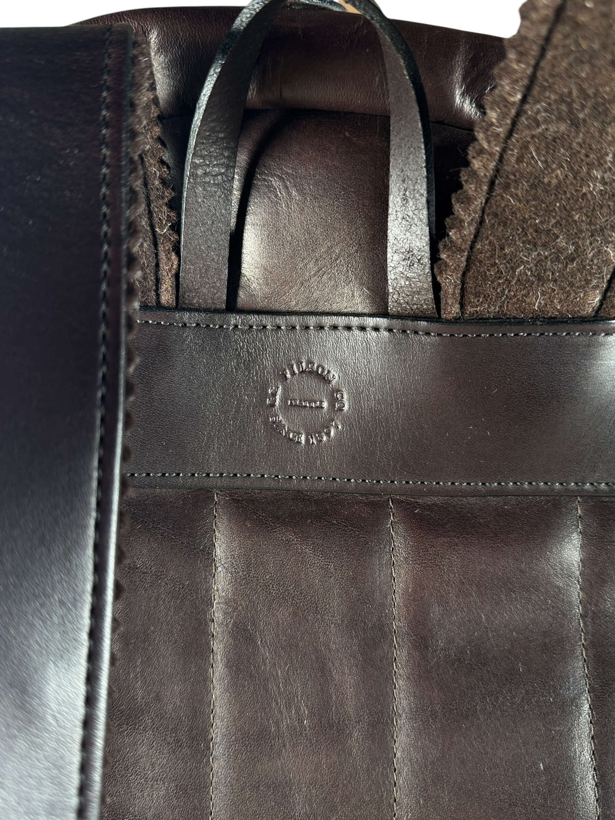 Embossed logo on back of Filson Weatherproof Sierra Brown Leather Journeyman Backpack