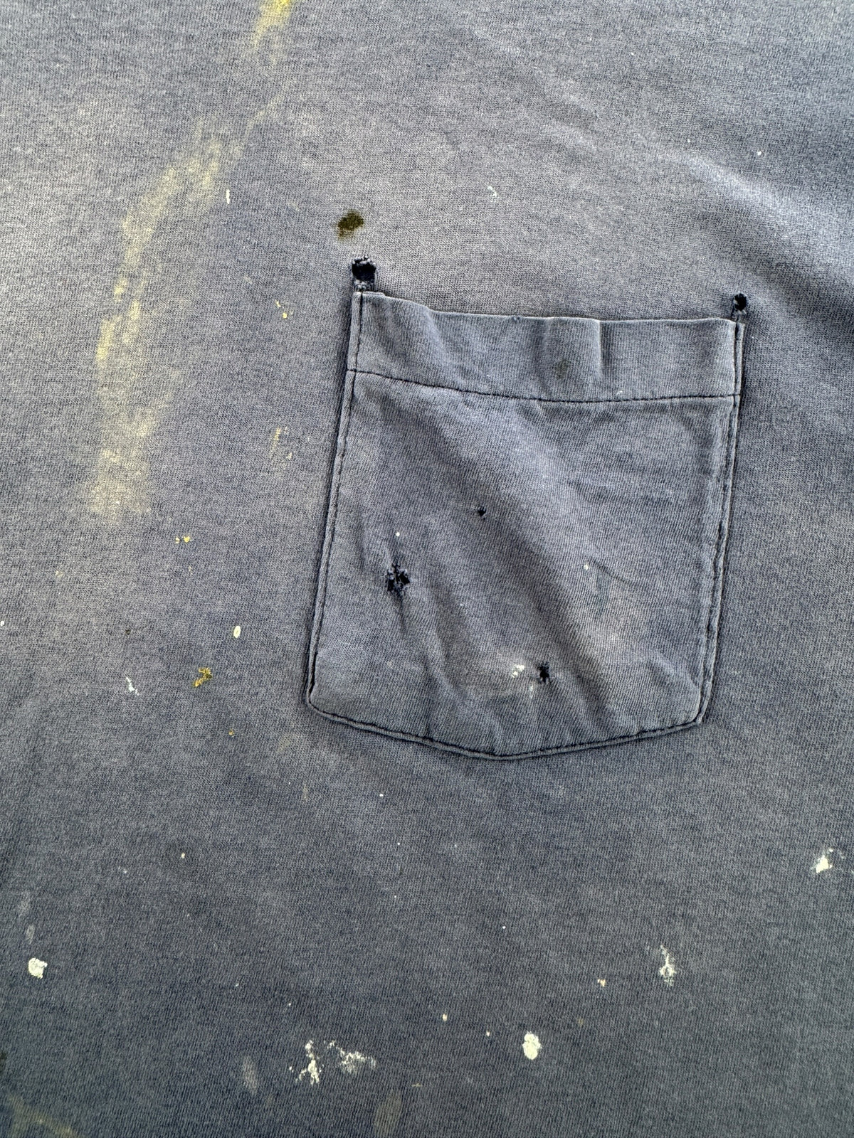 Pocket and paint stains on front of Vintage Distressed Navy Blue Pocket Tee SZ L