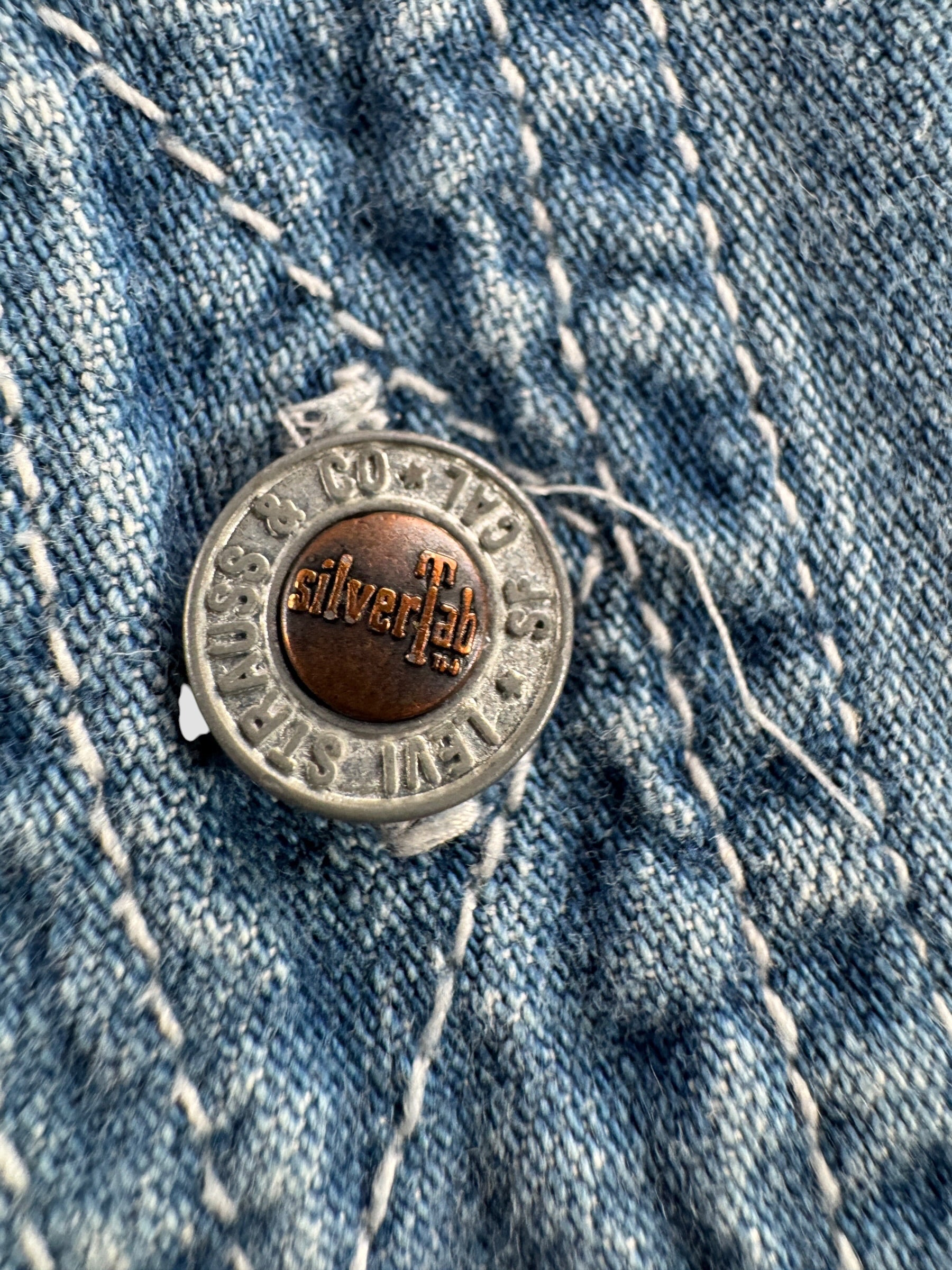 Close up of button on Vintage Levi's Silvertab Denim Button Up Shirt SZ L