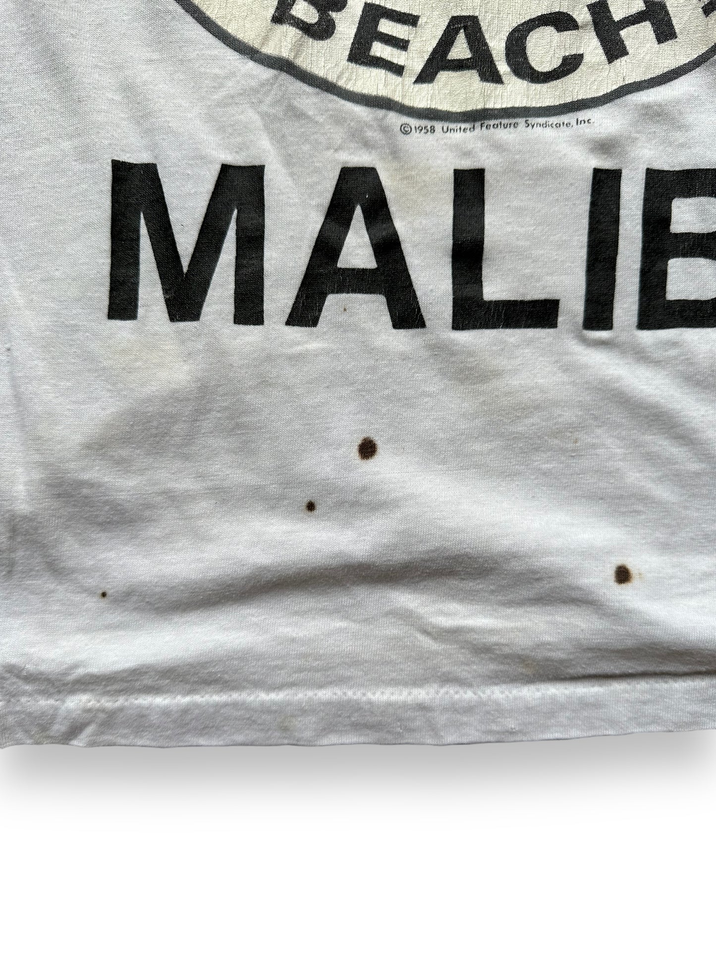 Stain shot of Vintage Snoopy Where's The Beach Malibu Tee SZ S | Vintage T-Shirts Seattle | Barn Owl Vintage Tees Seattle